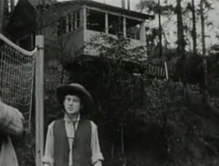 Mladík rozmlouvá s hajným před chatou