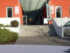 Před červenou budovou