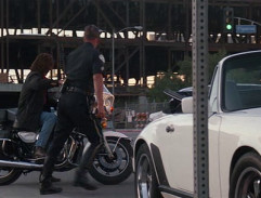 Riggs sedá na motorku