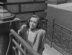 Schody, na kterých stojí Hana Vítová a pozoruje dění před domem.